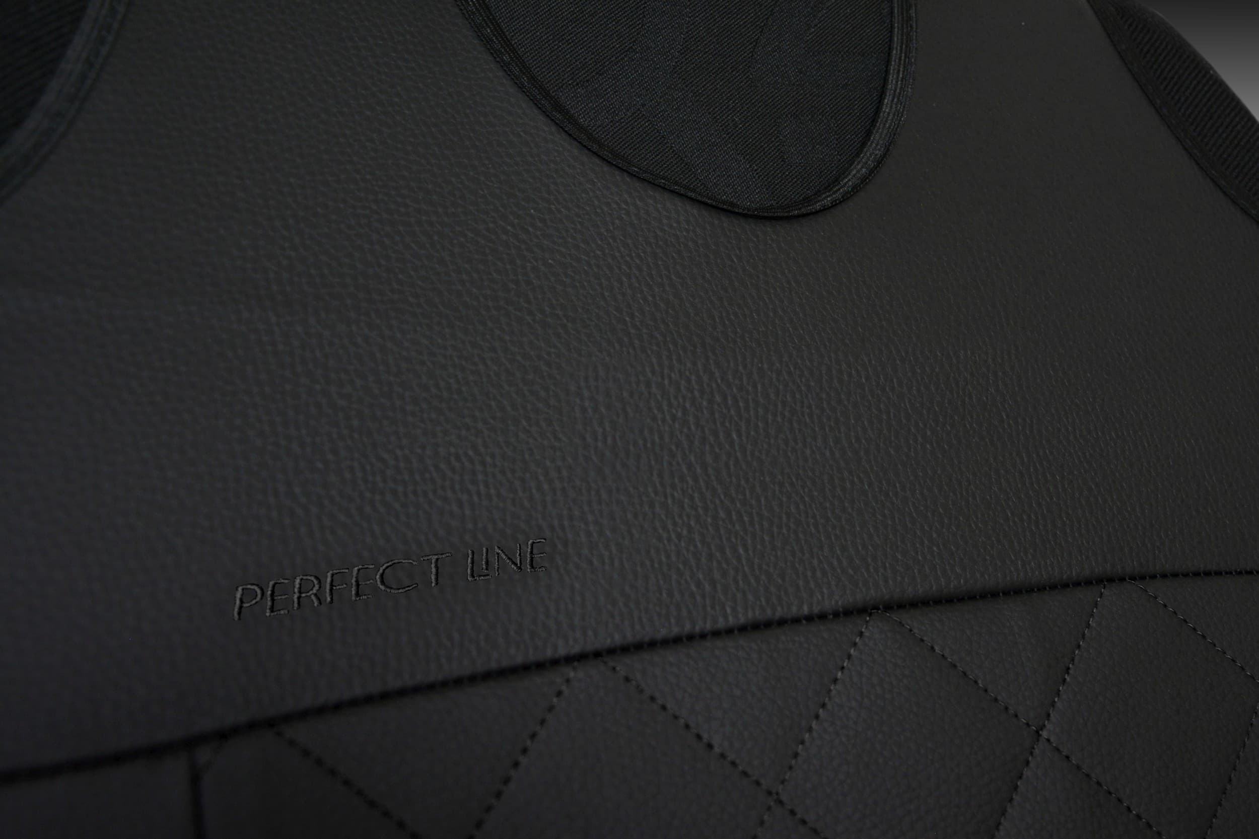 Détail de la broderie et des coutures sur simili cuir noir