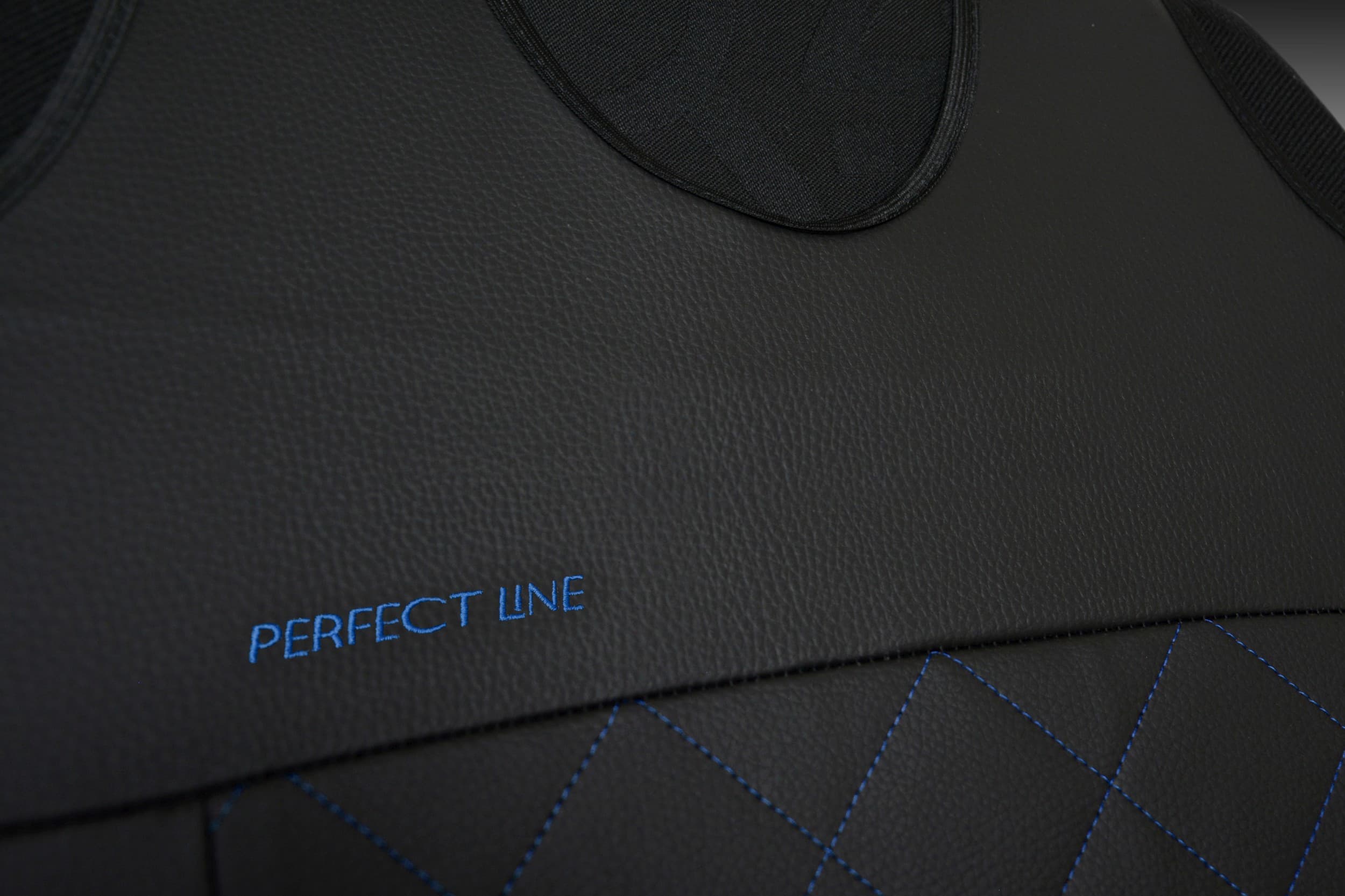 Détail de la broderie et des coutures sur simili cuir bleu